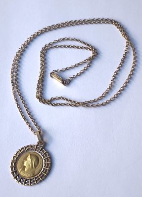 une chaîne en argent avec un pendentif en or sur lequel figure le portrait d'une femme