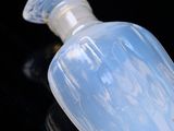 a clear glass bottle with a clear top on a black surface