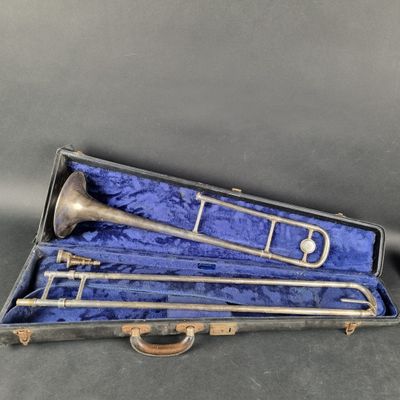un vieux trombone en laiton dans un étui doublé de velours bleu