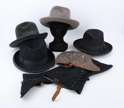 trois chapeaux et une ceinture sont posés sur une surface blanche