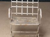 a white metal chair that is sitting on the floor