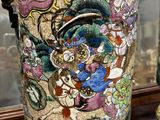 a vase with a painting on it sitting on a window sill
