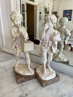 two figurines that are sitting on a marble table