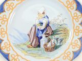 a plate with a picture of a woman sitting on a hill