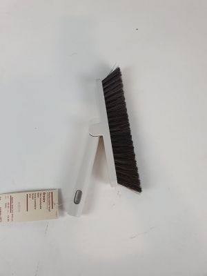 a brush that is next to a ruler on a table