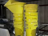 yellow buckets are stacked on top of each other in a garage