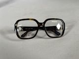 une paire de lunettes posée sur une surface blanche