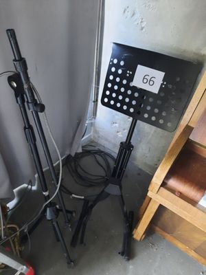a black music stand with a note on it next to a chair