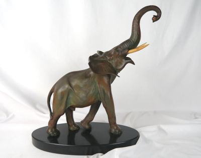 statue d'un éléphant avec des défenses, posée sur un socle noir