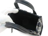 a black purse with a white glove on top of it