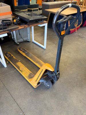 un chariot sur lequel est posé un ordinateur portable, dans un entrepôt