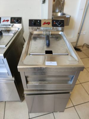 deux friteuses posées par terre dans la cuisine