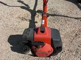 a small red machine that is sitting on the ground