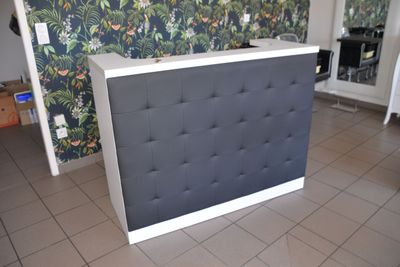 a black and white reception desk in a room
