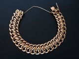une image représentant un collier à chaîne en or sur fond noir