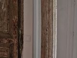 a tall column in the corner of a room next to a door