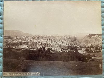 an old photo of a view of a city from a hill