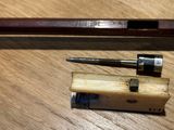 two pens and a pencil sitting on a wooden table