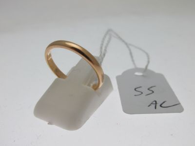 une bague en or et une étiquette blanche posées sur une table blanche