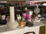 une table sur laquelle se trouvent une lampe, un vase et d'autres objets