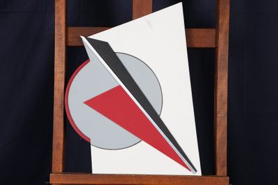 une photo d'un chevalet en bois sur lequel figure un triangle rouge et blanc