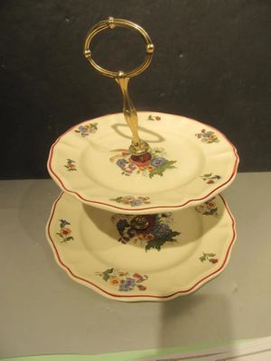une assiette à trois étages munie d'une poignée dorée