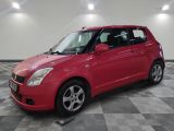 la petite voiture rouge est garée dans le garage sur un sol en damier