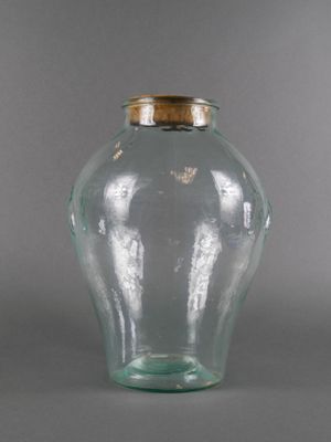 a glass vase with a gold lid sitting on a table