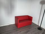 un canapé rouge dans un coin de la pièce