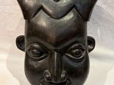 an image of a black sculpture of a man ' s face on a white background