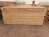 several pieces of wood stacked on top of each other in front of a building