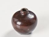 a small brown vase sitting on a white surface