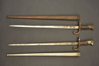 three old swords are sitting next to each other on a table