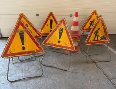 five warning signs that are sitting on the ground