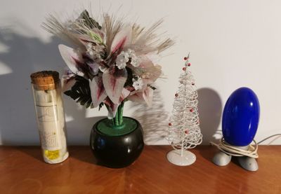 a vase of flowers and a bottle of wine on a table