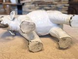 a white elephant that is laying down on a bed