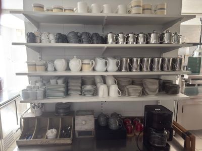 many plates and cups on the shelves in the kitchen