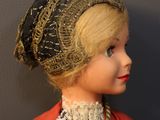 a doll that is wearing a red coat and a black hat
