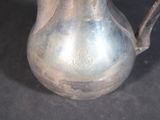 a silver pitcher that is sitting on a table