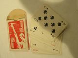 Plusieurs cartes à jouer sont posées sur une table, à côté d'une liasse de cartes à jouer.