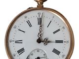 a gold pocket watch with roman numerals on the face