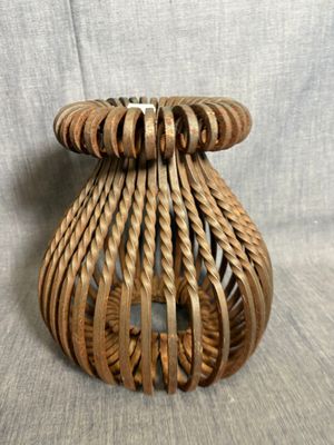 a wicker candle holder with a candle inside of it