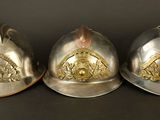 three firemen helmets sitting next to each other on a table