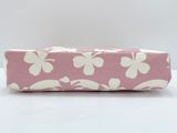 a close up of a pink and white pencil case on a white surface
