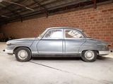 a silver car parked in a garage next to a brick wall
