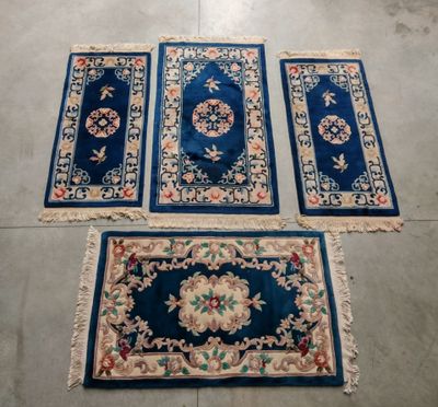 trois tapis et un tapis posé à même le sol dans une pièce