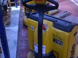 yellow forklifts are lined up in a warehouse with pallets in the background