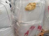 une palette remplie de grands sacs contenant une matière blanche
