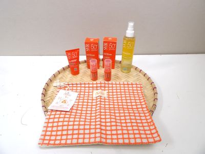 bottles of sunscreen and lotion sitting on a basket on a table