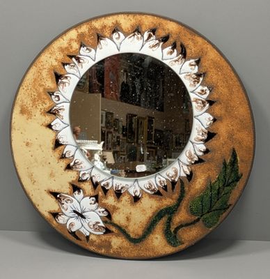 un miroir rond orné d'une image de fleur